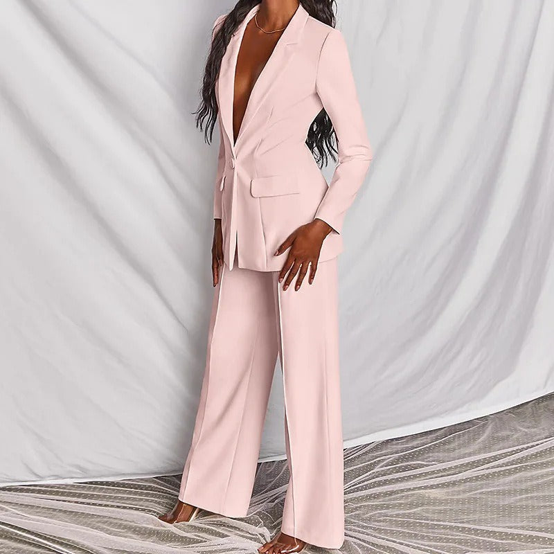 Model wearing a pink blazer and trouser suit, angled view