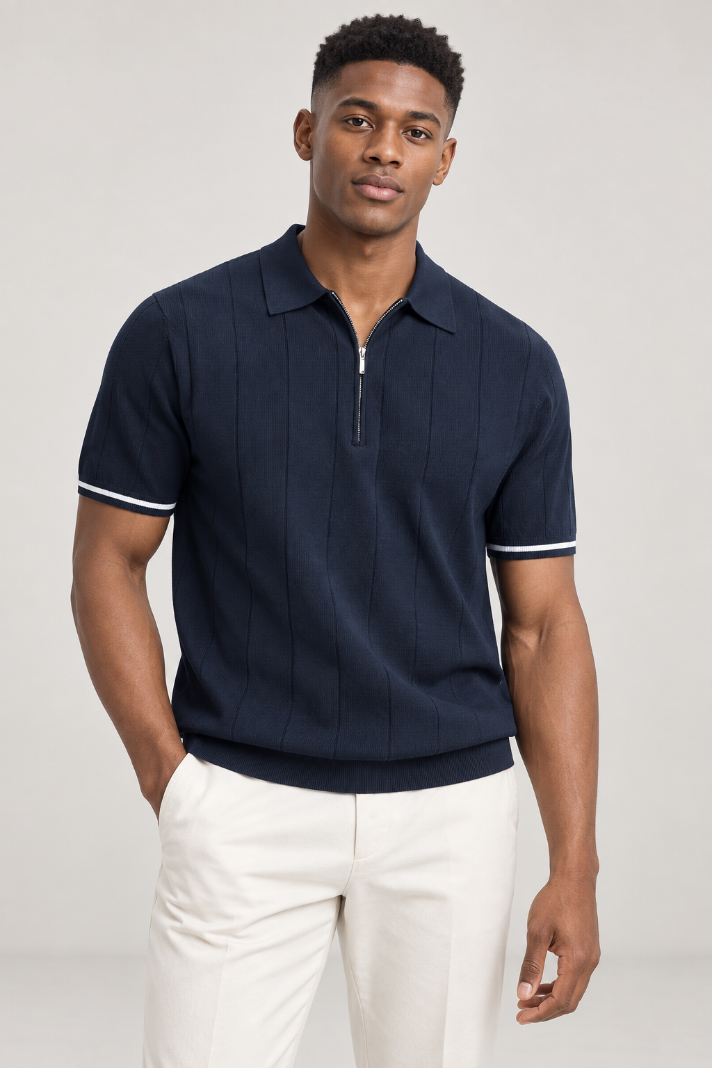 Model wearing a navy zip polo with cream trousers