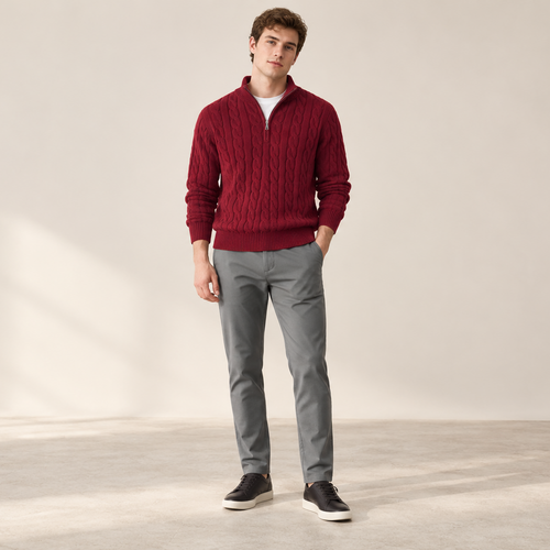 Model wearing a burgundy cable-knit sweater and grey trousers