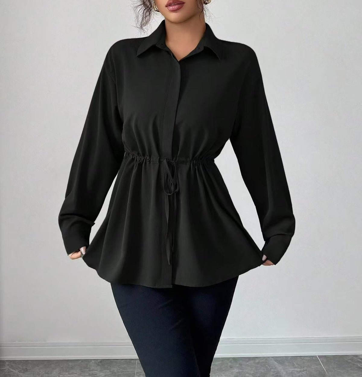 Model wearing a black drawstring-waist blouse
