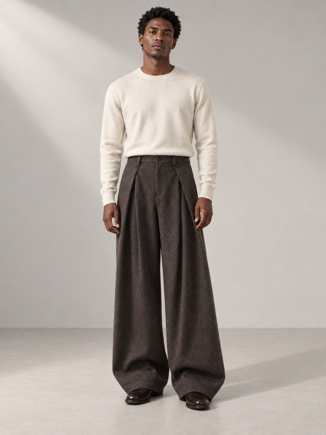 Model wearing coffee vintage pleated wide-leg trousers with an ivory knit top.
