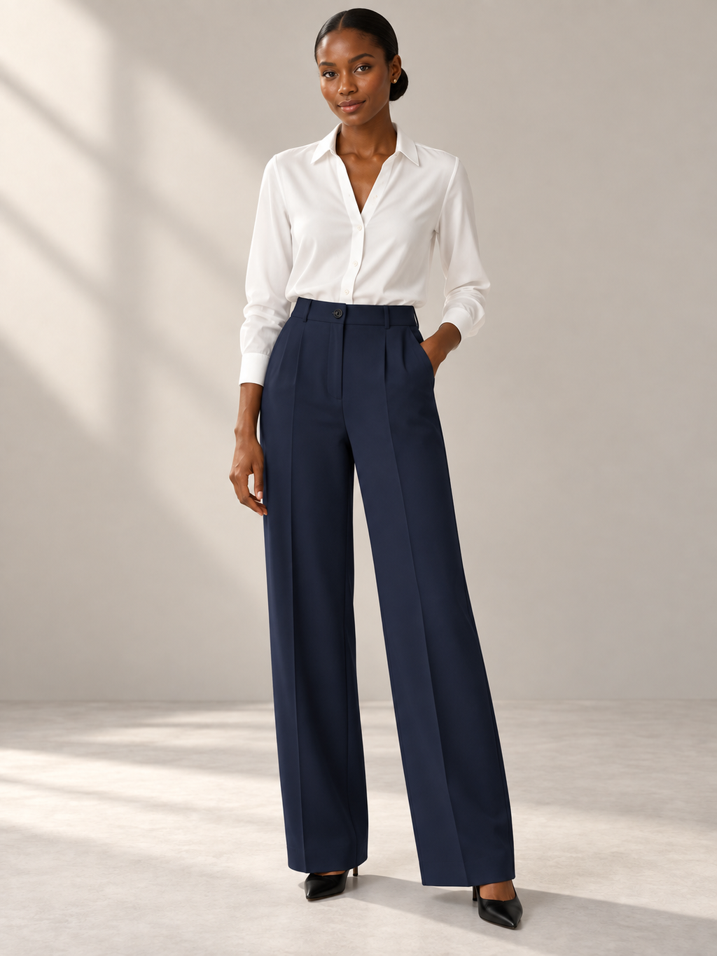 Model wearing dark navy high-waist wide-leg trousers with a white blouse.